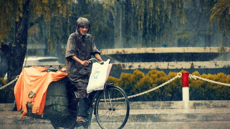 Man riding bike in the rain