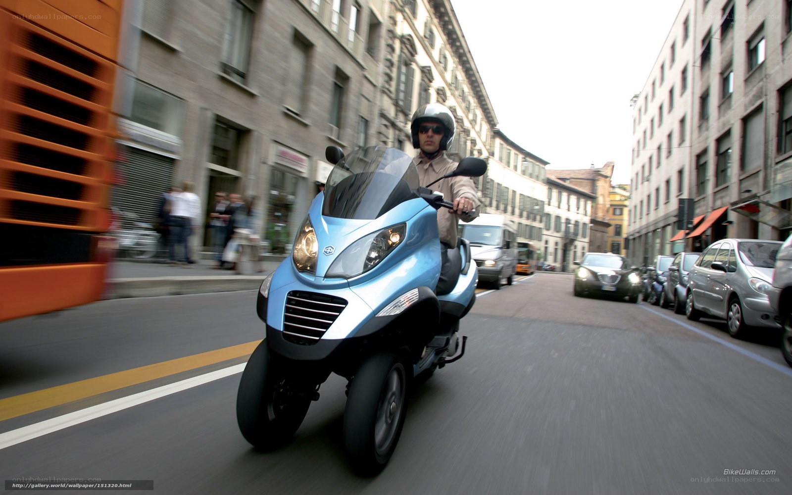 Man riding blue three-wheeled scooter