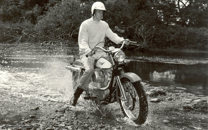 Man riding motorcycle through river