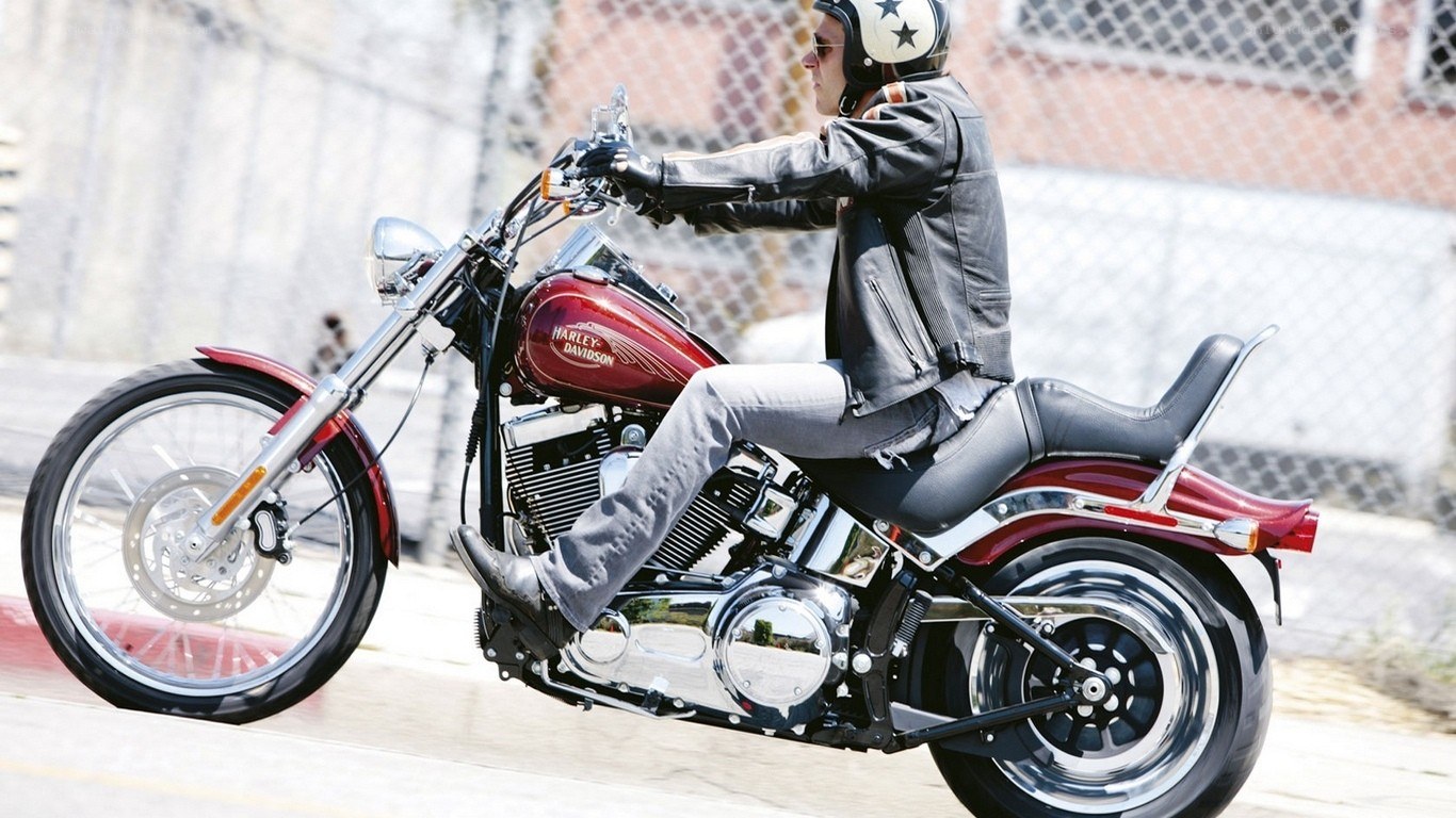 man riding red harley motorcycle