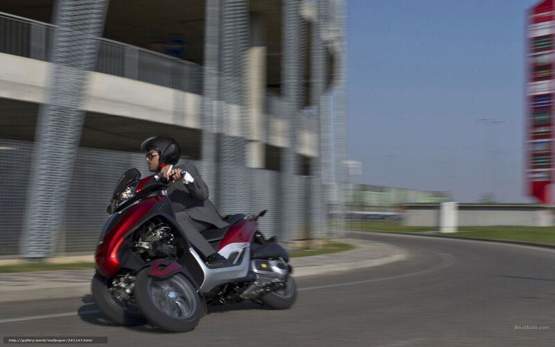Man riding red scooter on road