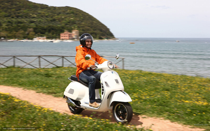 Man riding scooter by the sea
