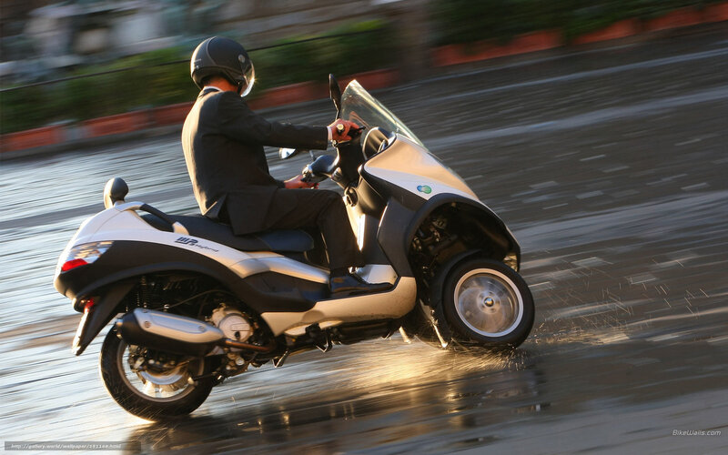 Man riding scooter in rain
