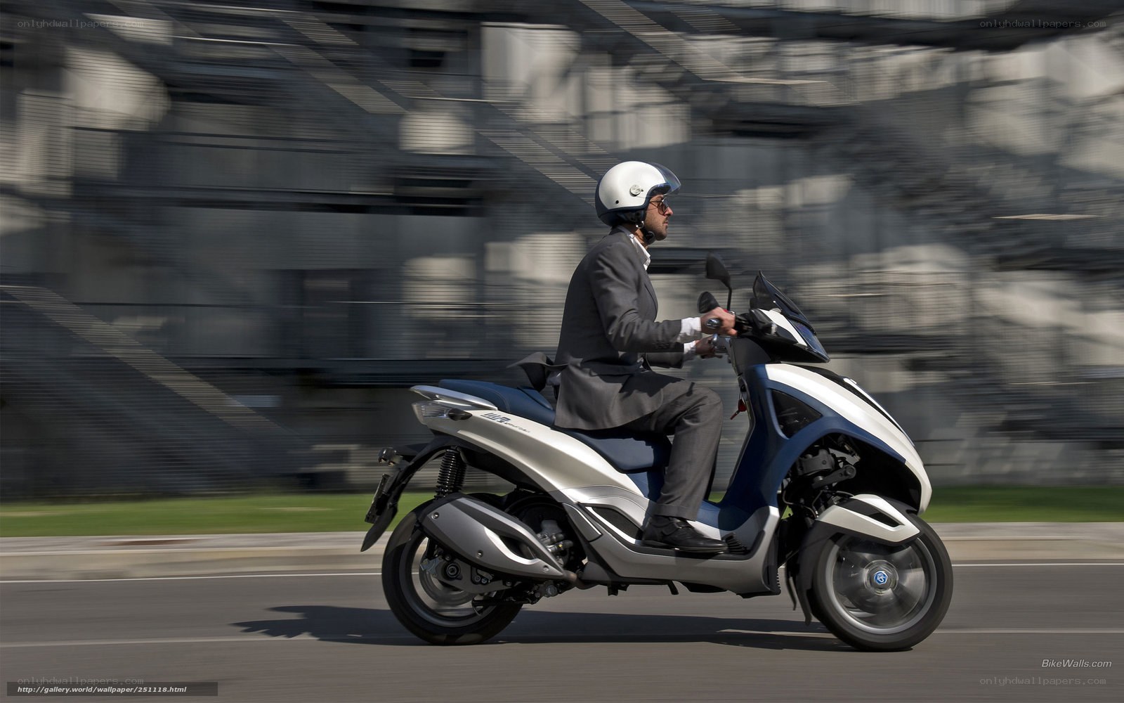 Man riding scooter in suit