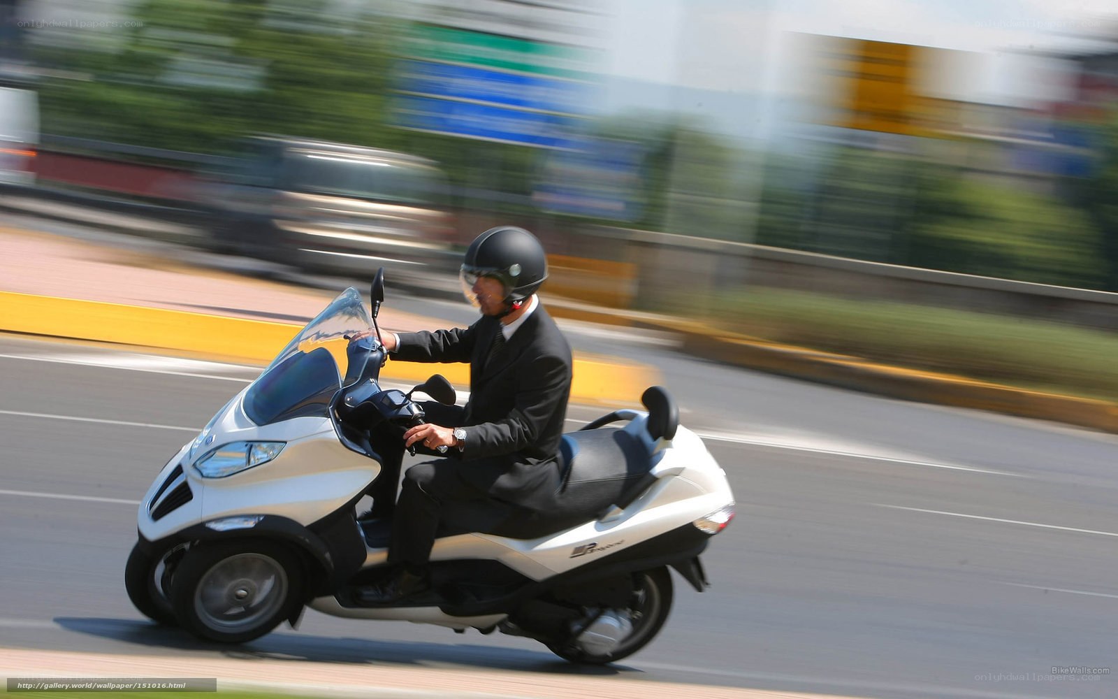Man riding scooter in suit