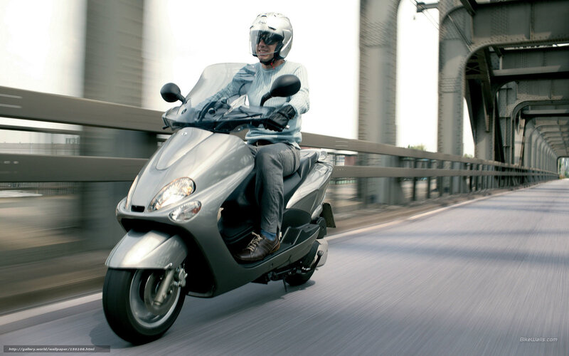Man riding scooter on bridge