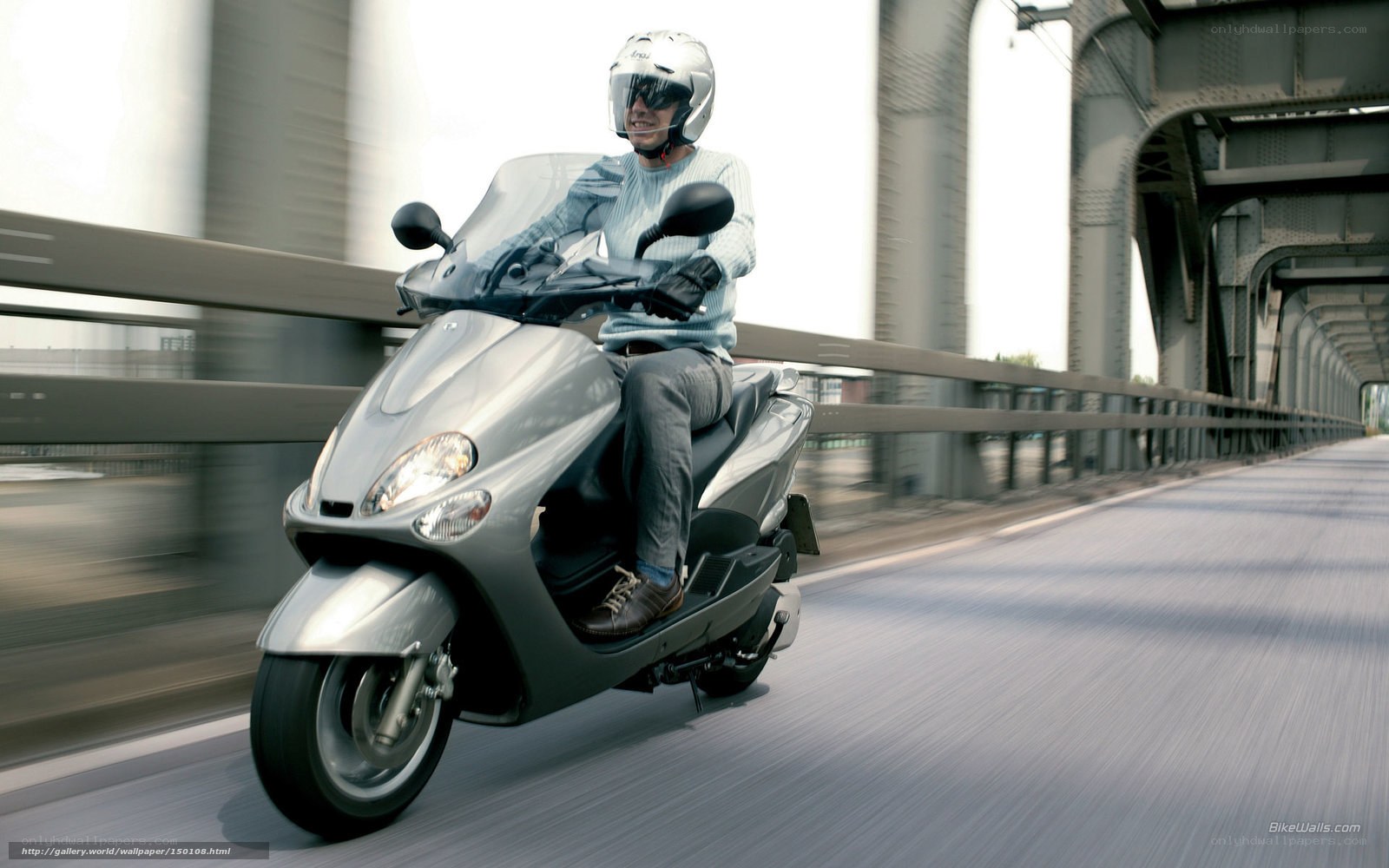 Man riding scooter on bridge