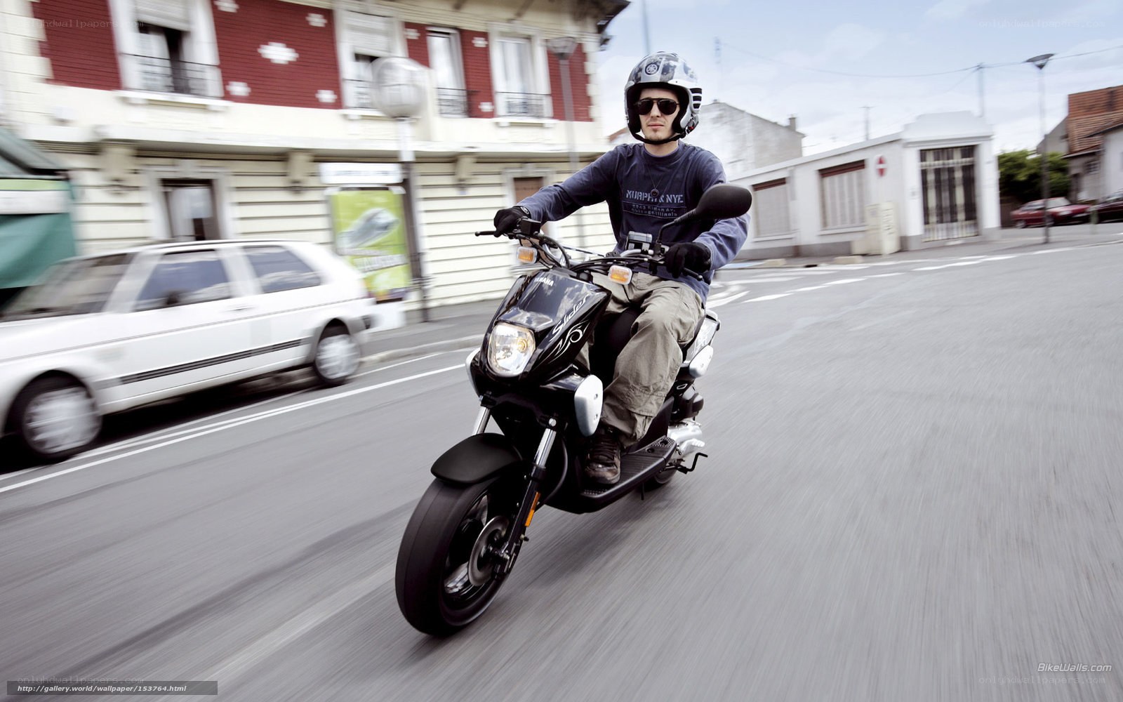 man riding scooter on city street