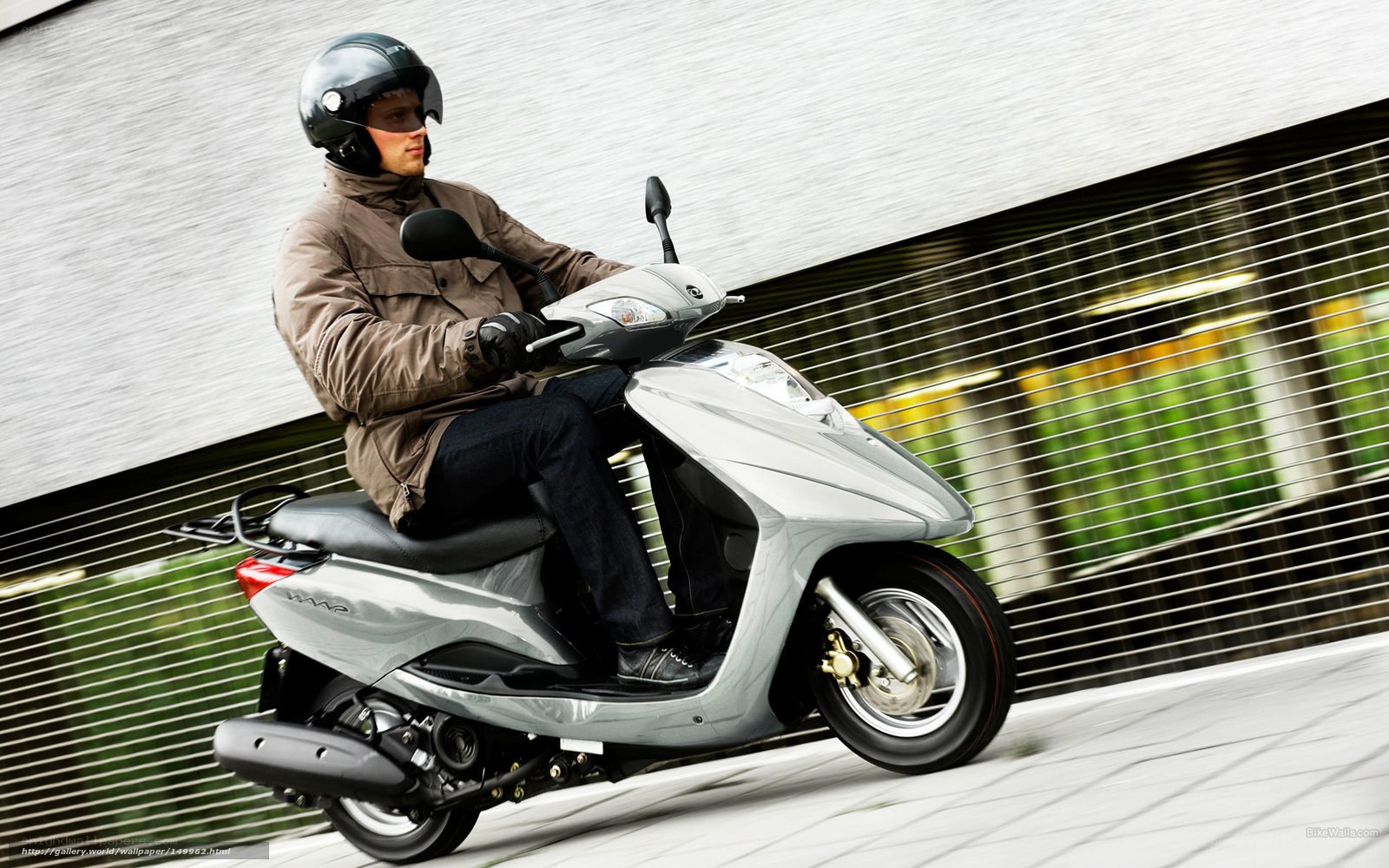 Man riding silver scooter