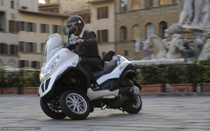 Man riding white three-wheeled scooter