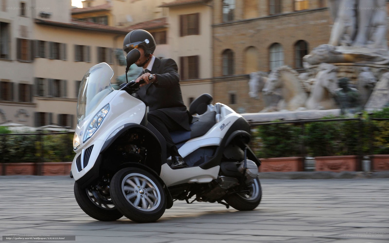 Man riding white three-wheeled scooter