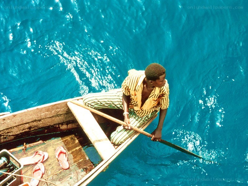 Man rowing a boat on blue water