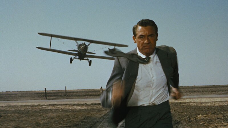 man running from biplane
