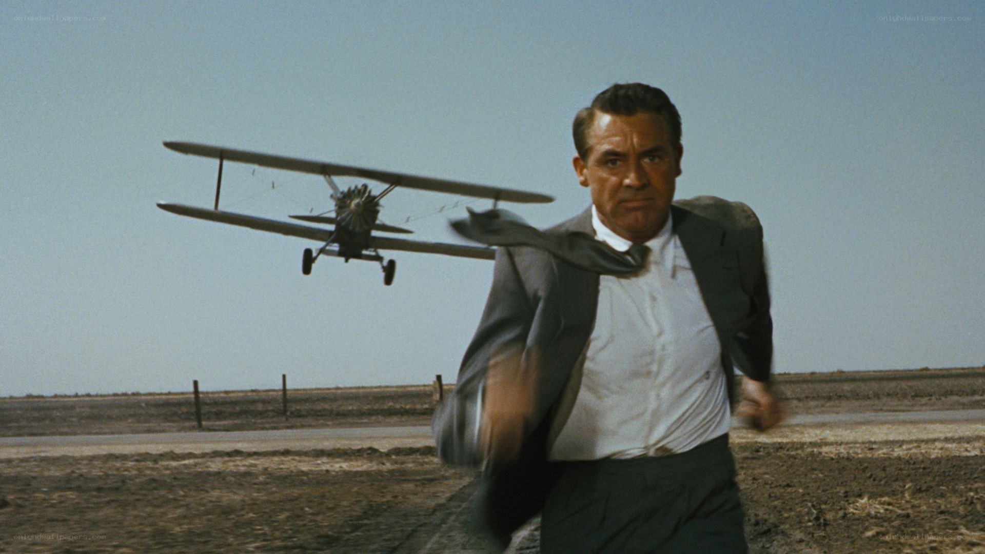 man running from biplane