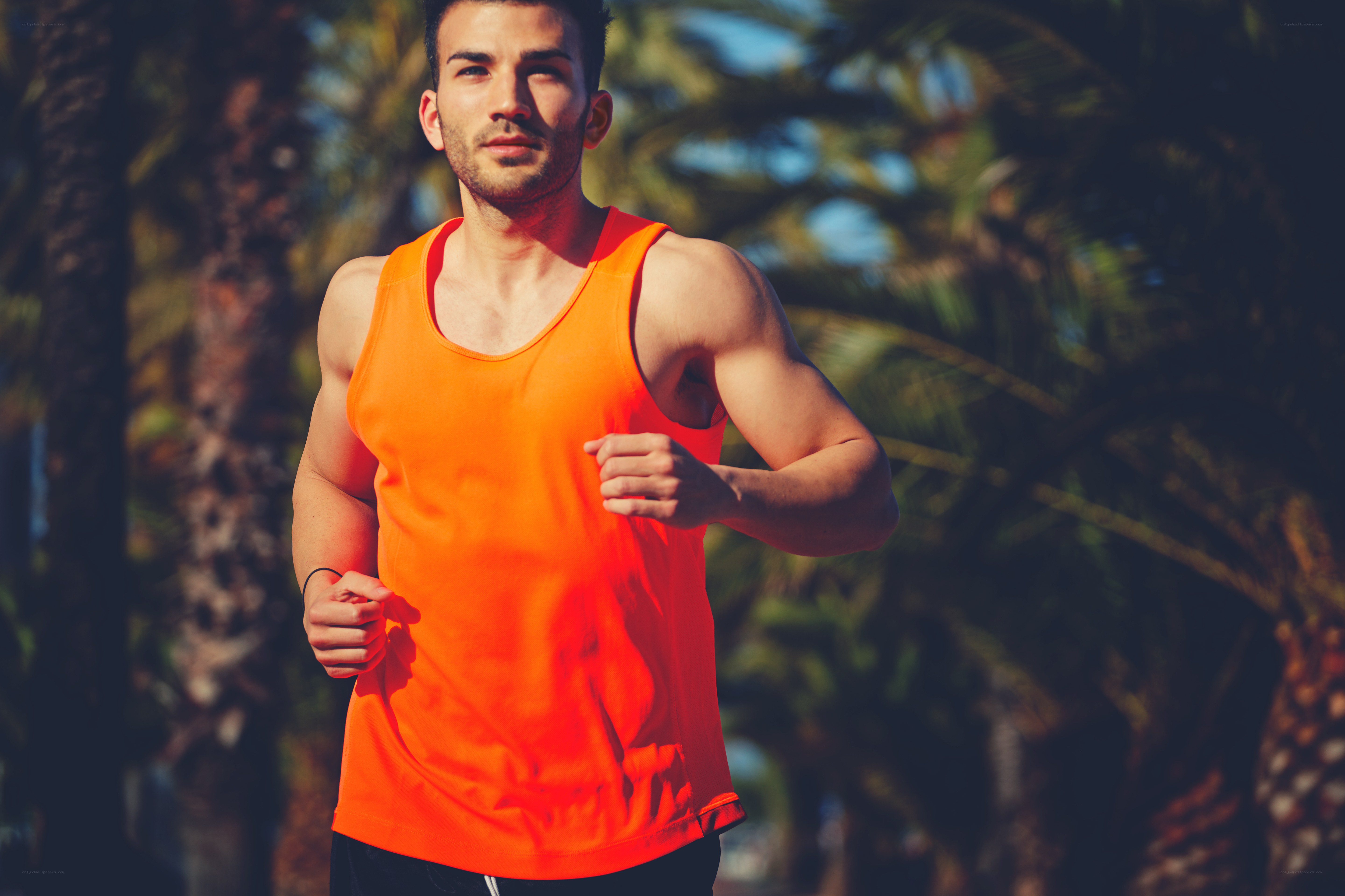 man running in orange tank top
