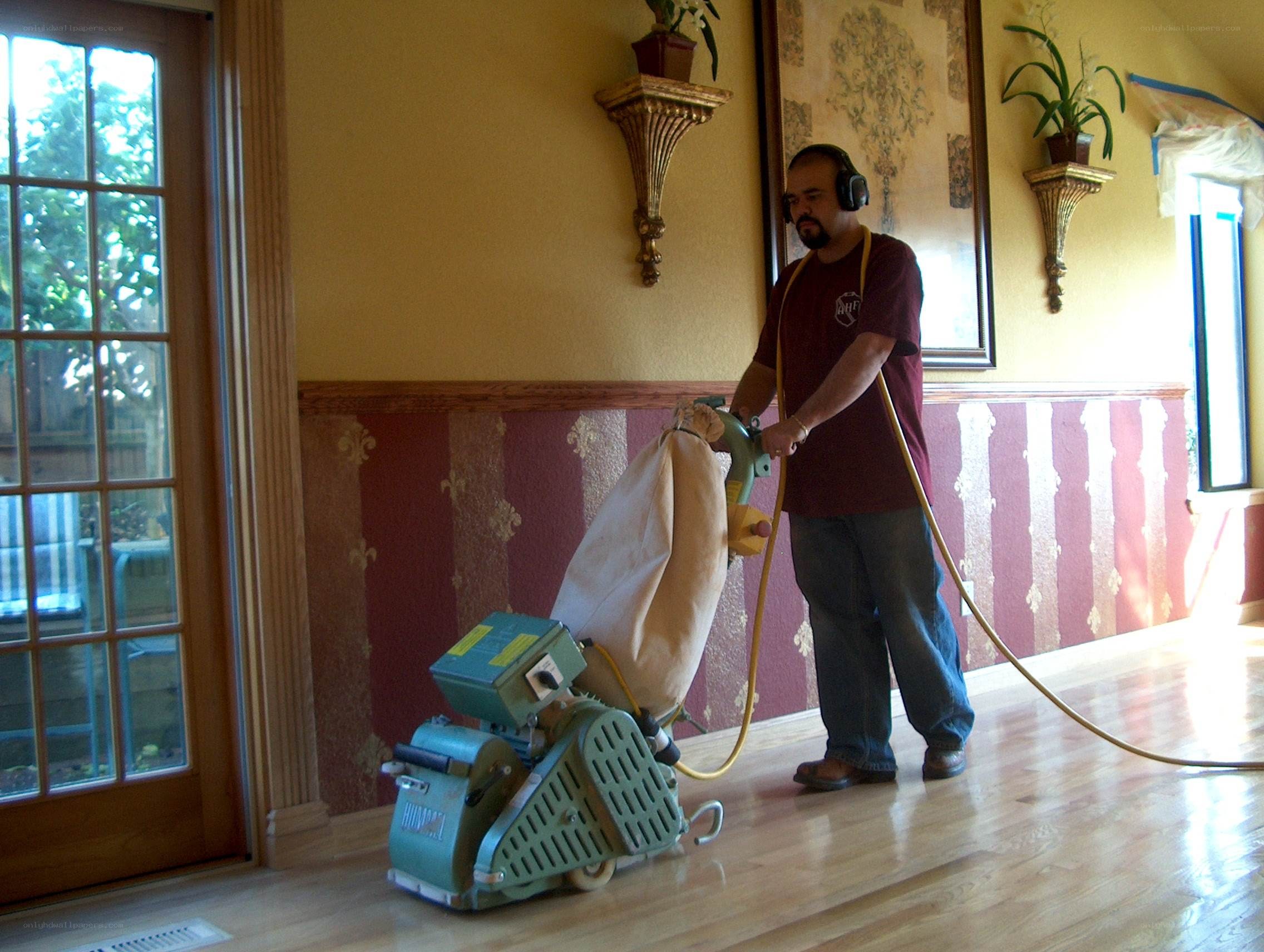 Man sanding hardwood floor