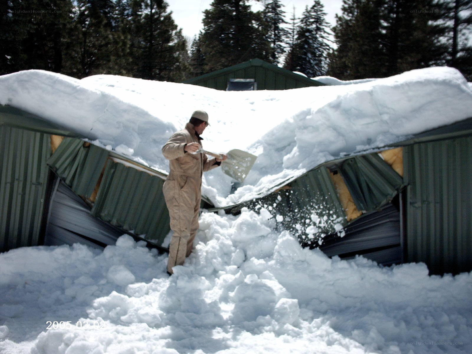 Man shoveling snow from collapsed shed