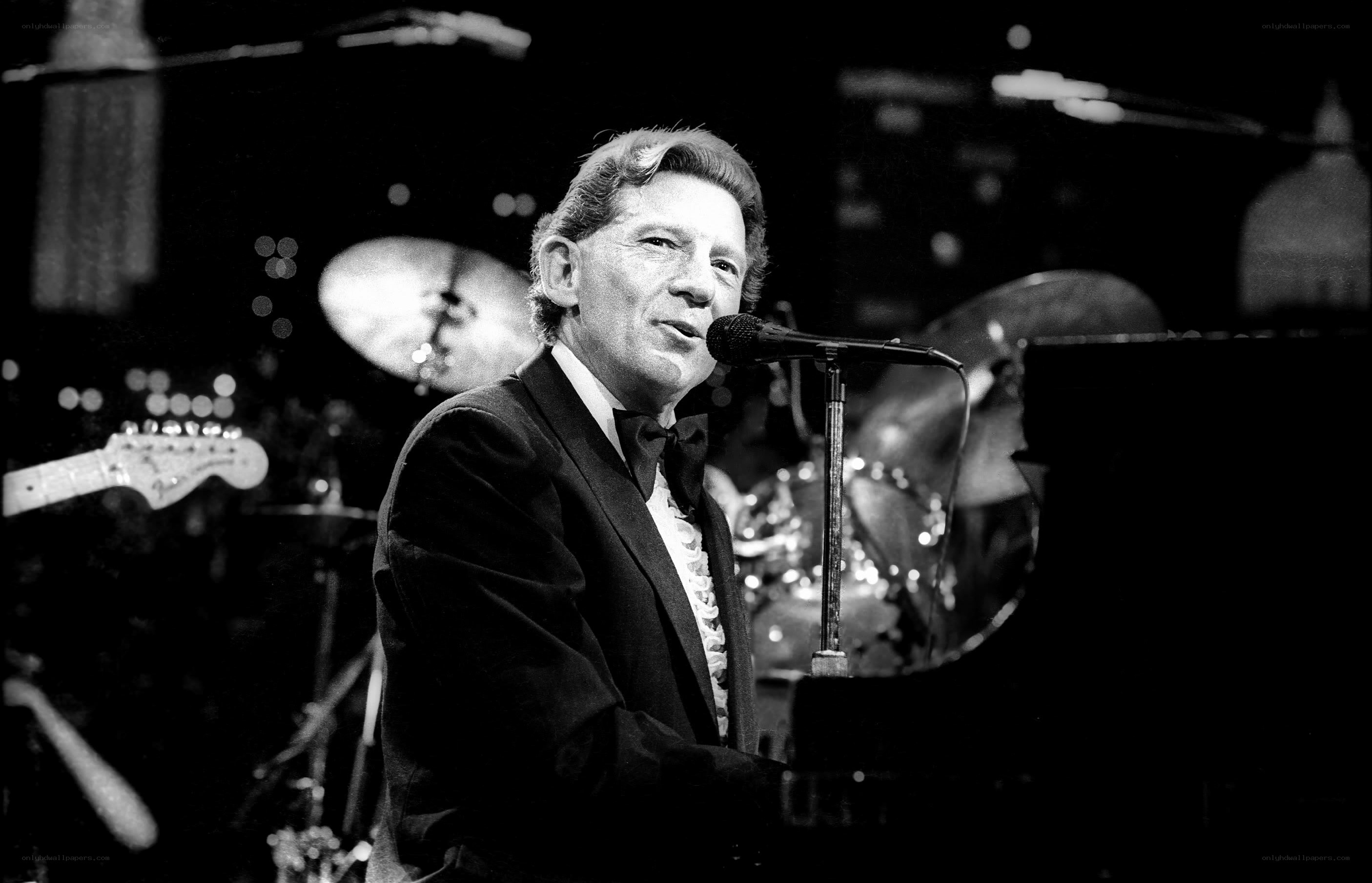 Man singing at piano on stage