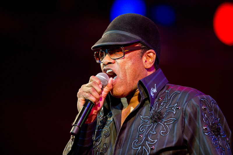 Man Singing into Microphone — Black, Dramatic, Night, Photograph, Hat, Glasses