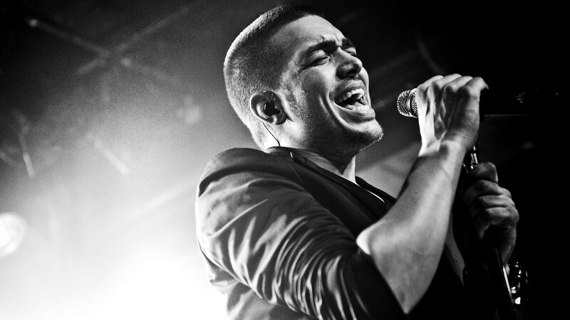 Man Singing into Microphone — Black, Dramatic, Night, Photograph, Stage Light, Earpiece
