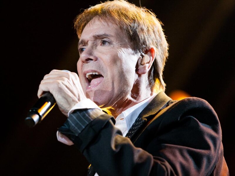 Man Singing into Microphone — Black, Dramatic, Photograph, Earpiece, Suit