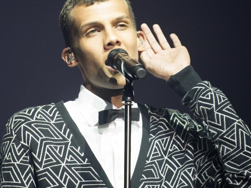 Man Singing into Microphone — Black, Dramatic, Photograph, Earpiece, Sweater
