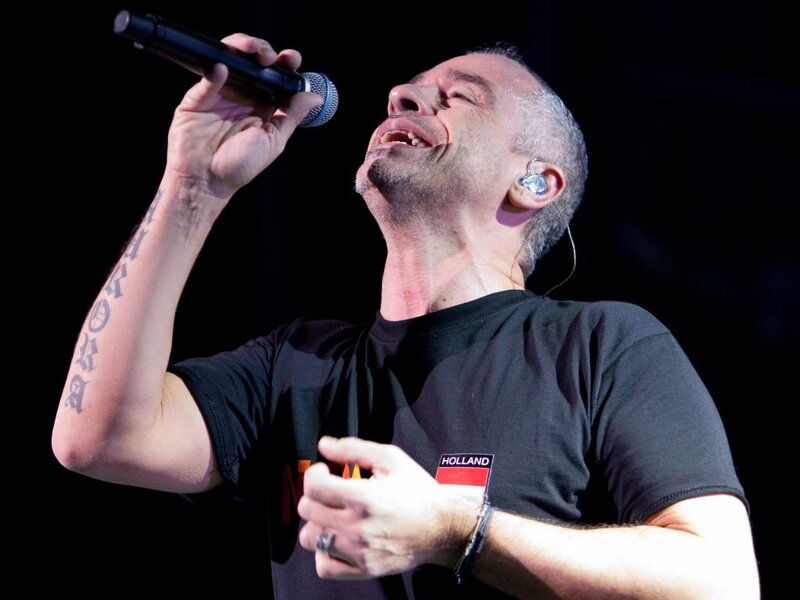 Man Singing into Microphone — Black, Intense, Photograph, Earpiece, Tattoo