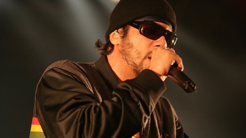 Man Singing into Microphone — Black, Intense, Photograph, Sunglasses, Beanie