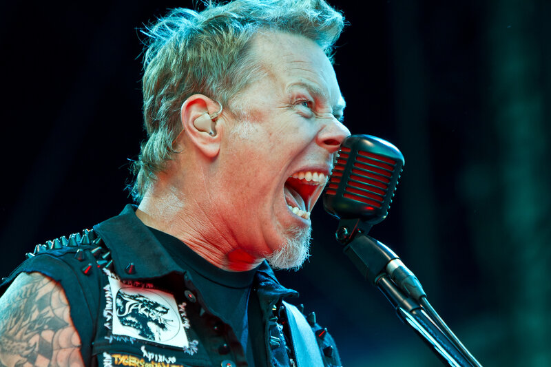 Man Singing into Microphone — Black, Intense, Photograph, Tattoo, Vest