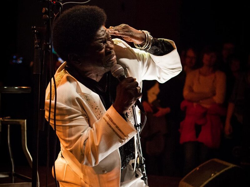 Man Singing on Stage — Black, Dramatic, Night, Photograph, Microphone, Audience