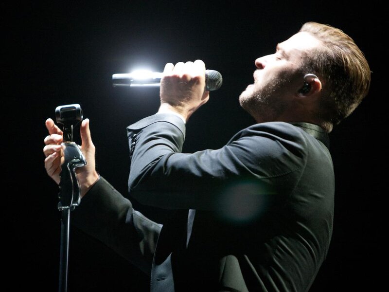 Man Singing on Stage — Black, Dramatic, Night, Photograph, Microphone, Earpiece