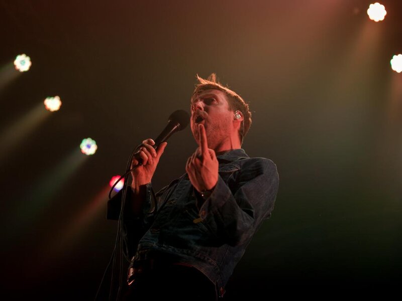 Man Singing on Stage — Black, Dramatic, Night, Photograph, Microphone, Stage Lights, Earpiece