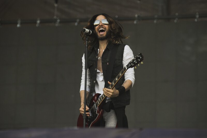 Man Singing on Stage — Black, Energetic, Photograph, Guitar, Microphone
