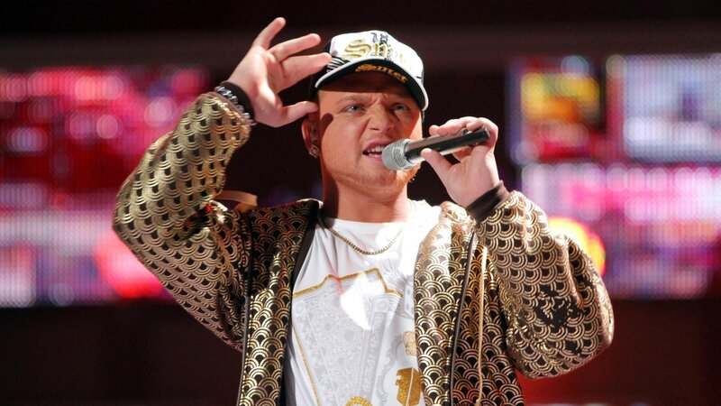 Man Singing on Stage — Black, Energetic, Photograph, Microphone, Cap