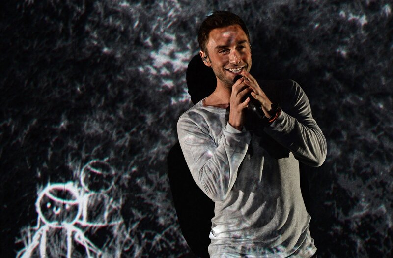 Man Singing on Stage — Black, Energetic, Photograph, Microphone, Stage Light