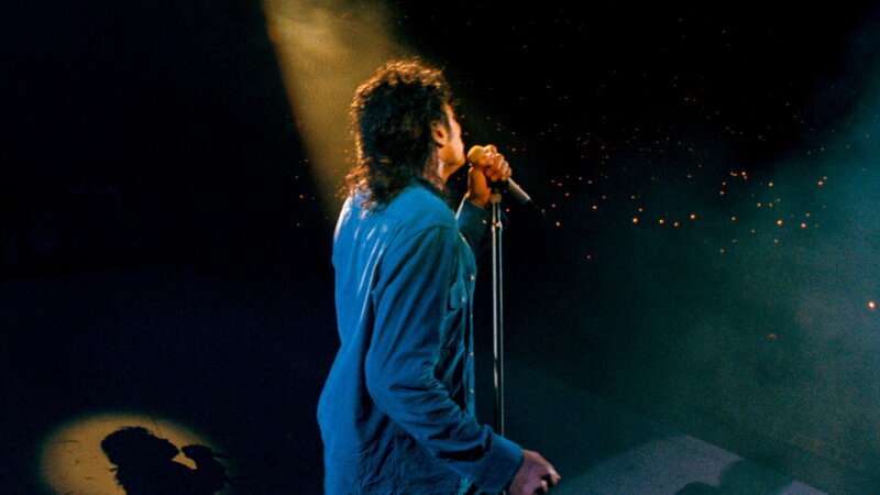 Man Singing on Stage — Blue, Dramatic, Night, Photograph, Microphone, Stage Light