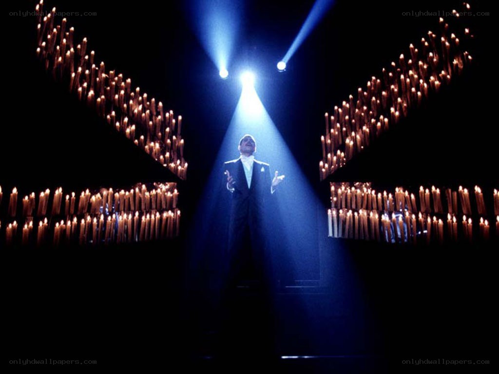 Man singing on stage with candles