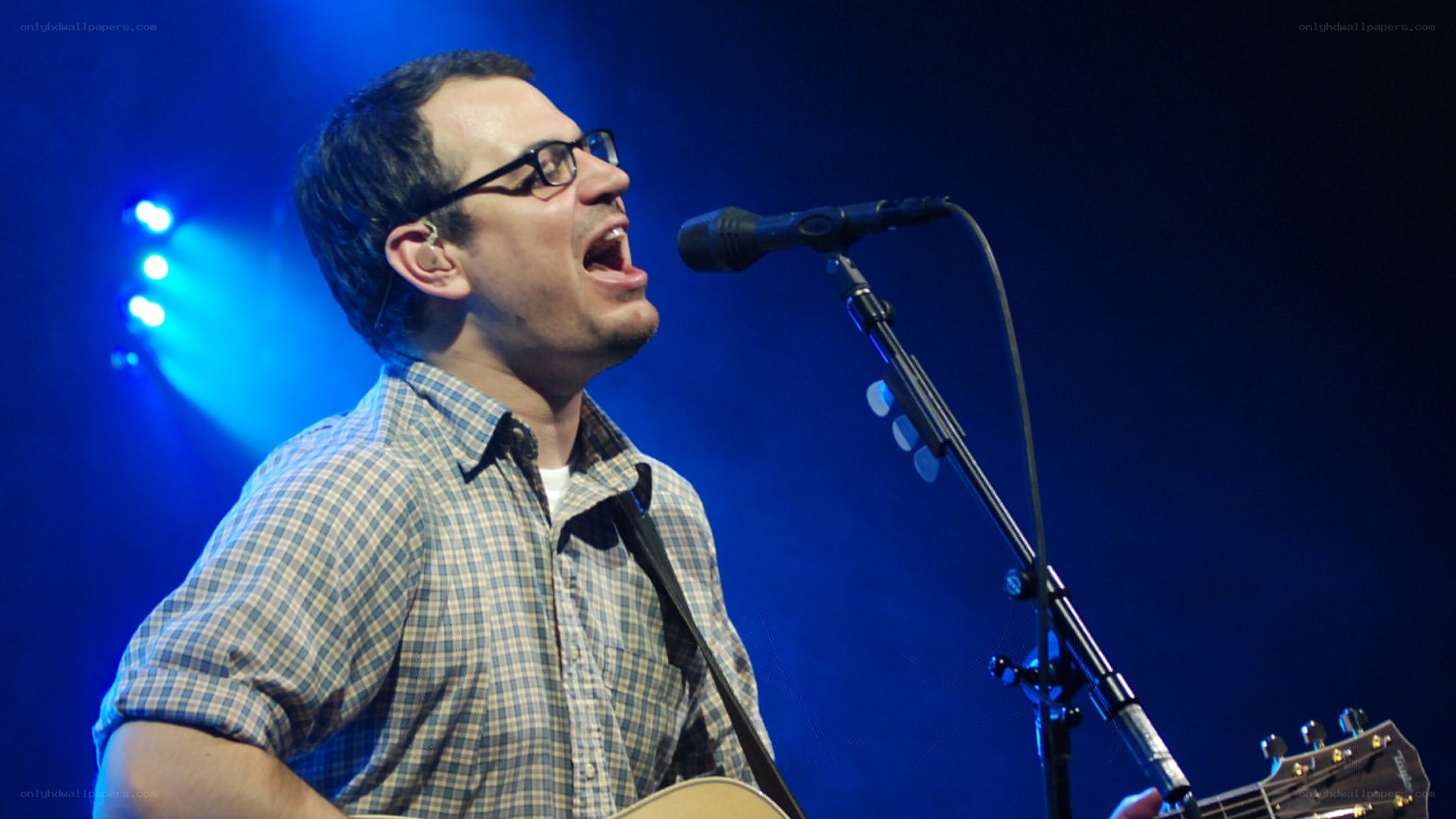 Man singing on stage with guitar