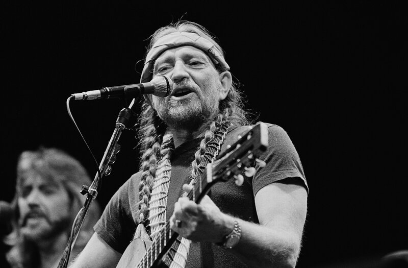 Man singing with guitar on stage