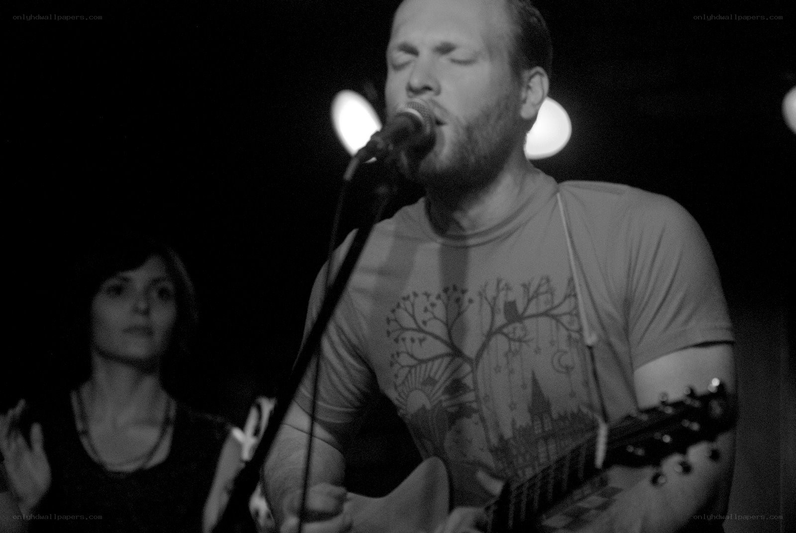 Man singing with guitar on stage