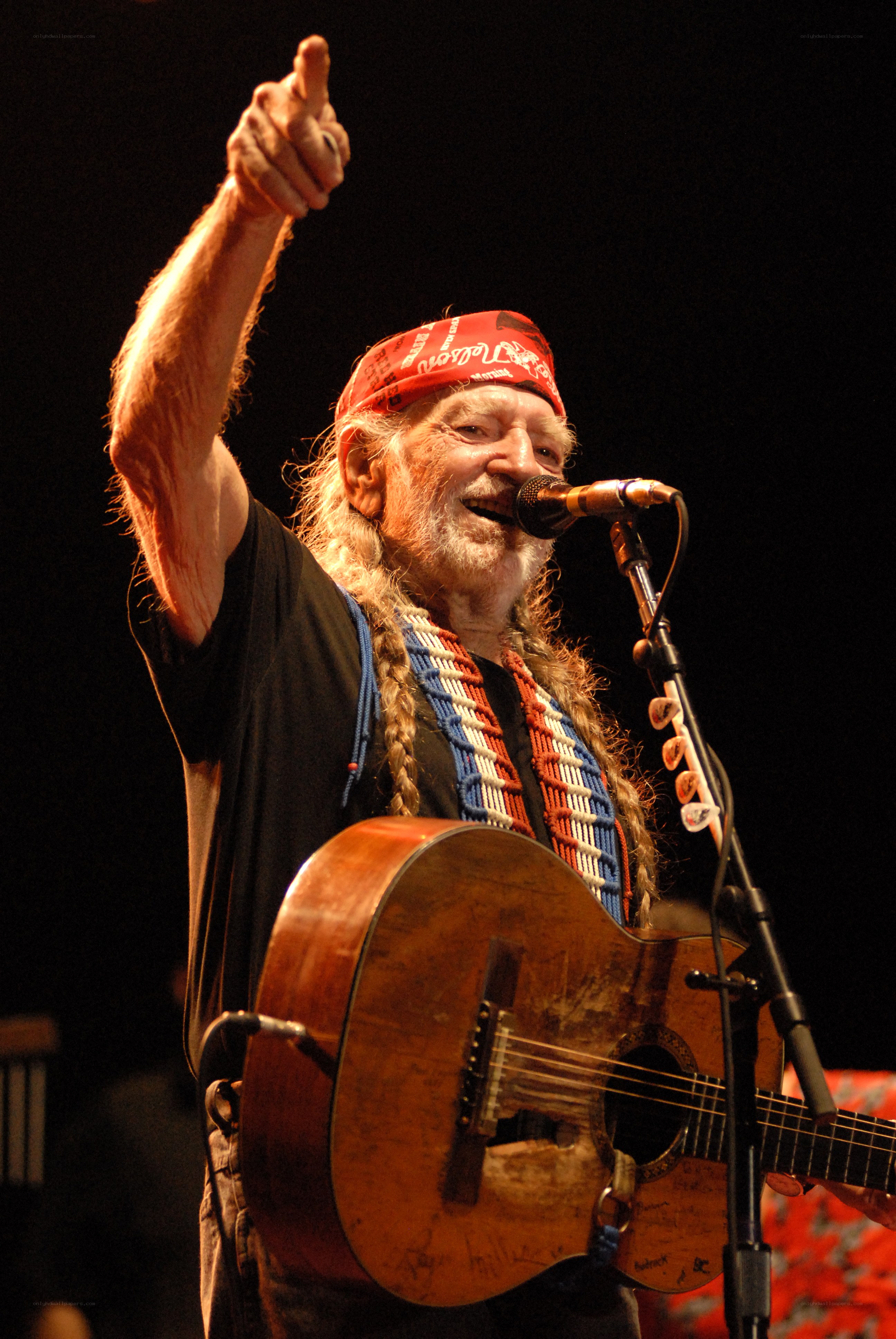 Man singing with guitar on stage