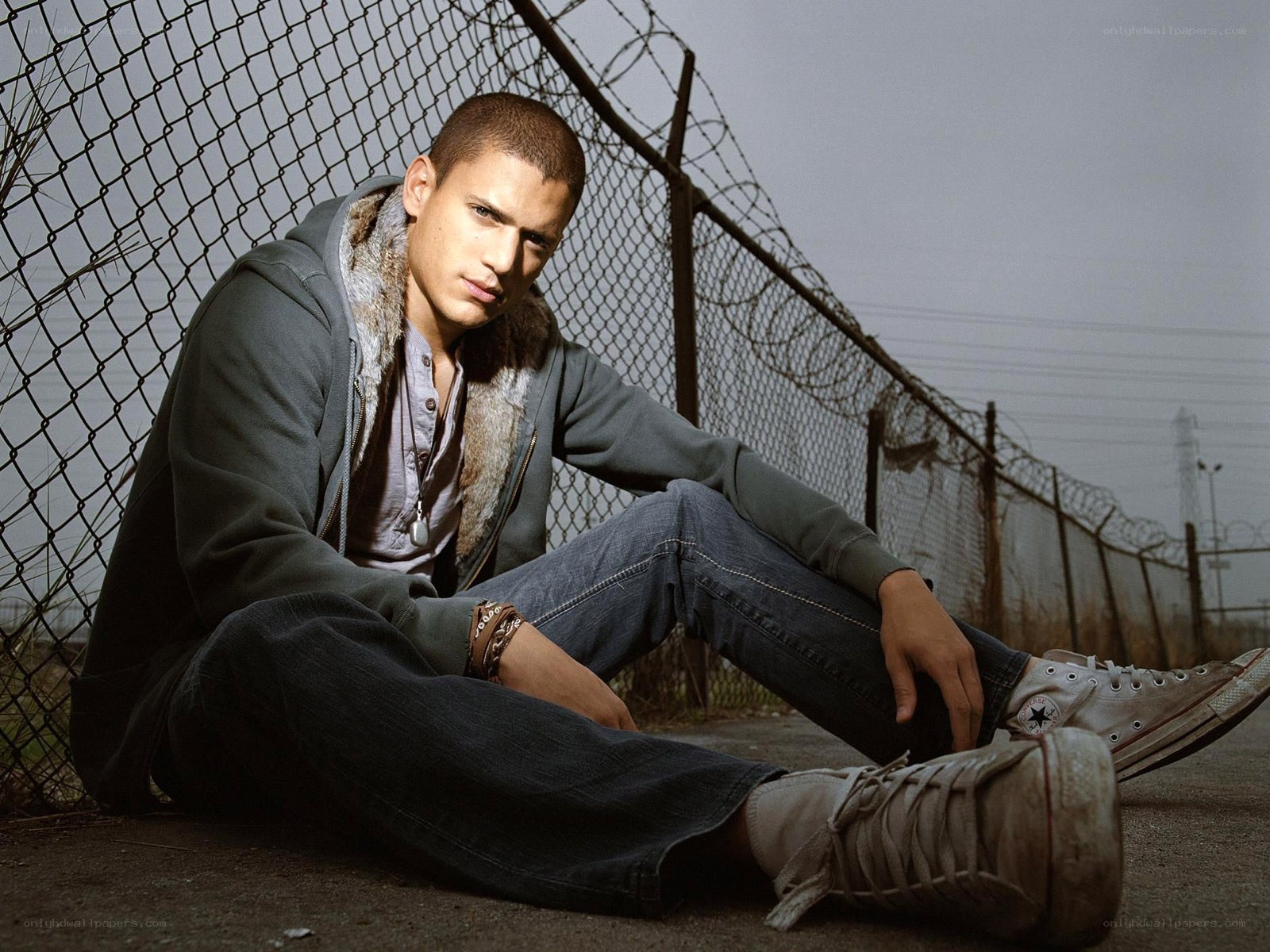 man sitting by fence