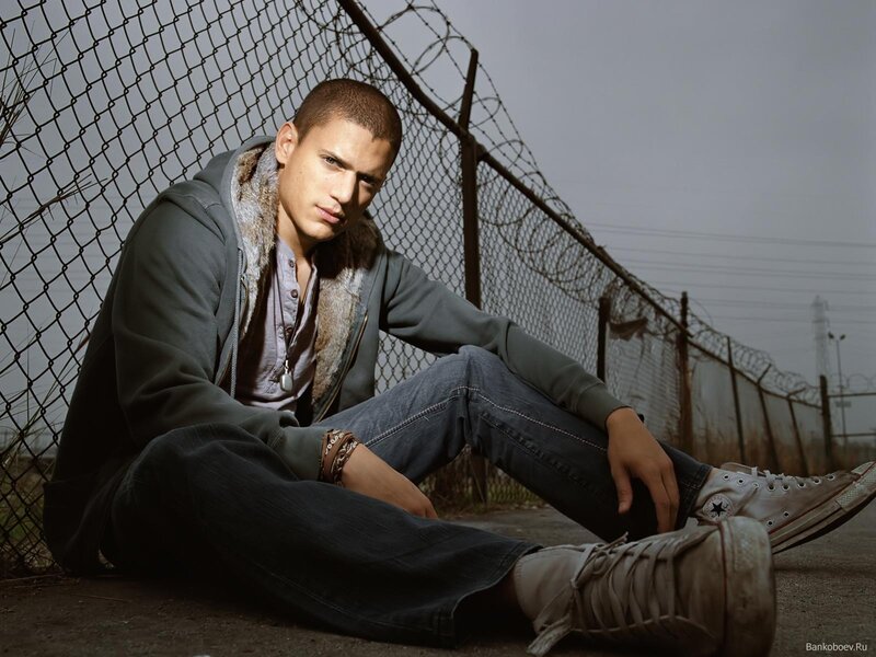 man sitting by fence