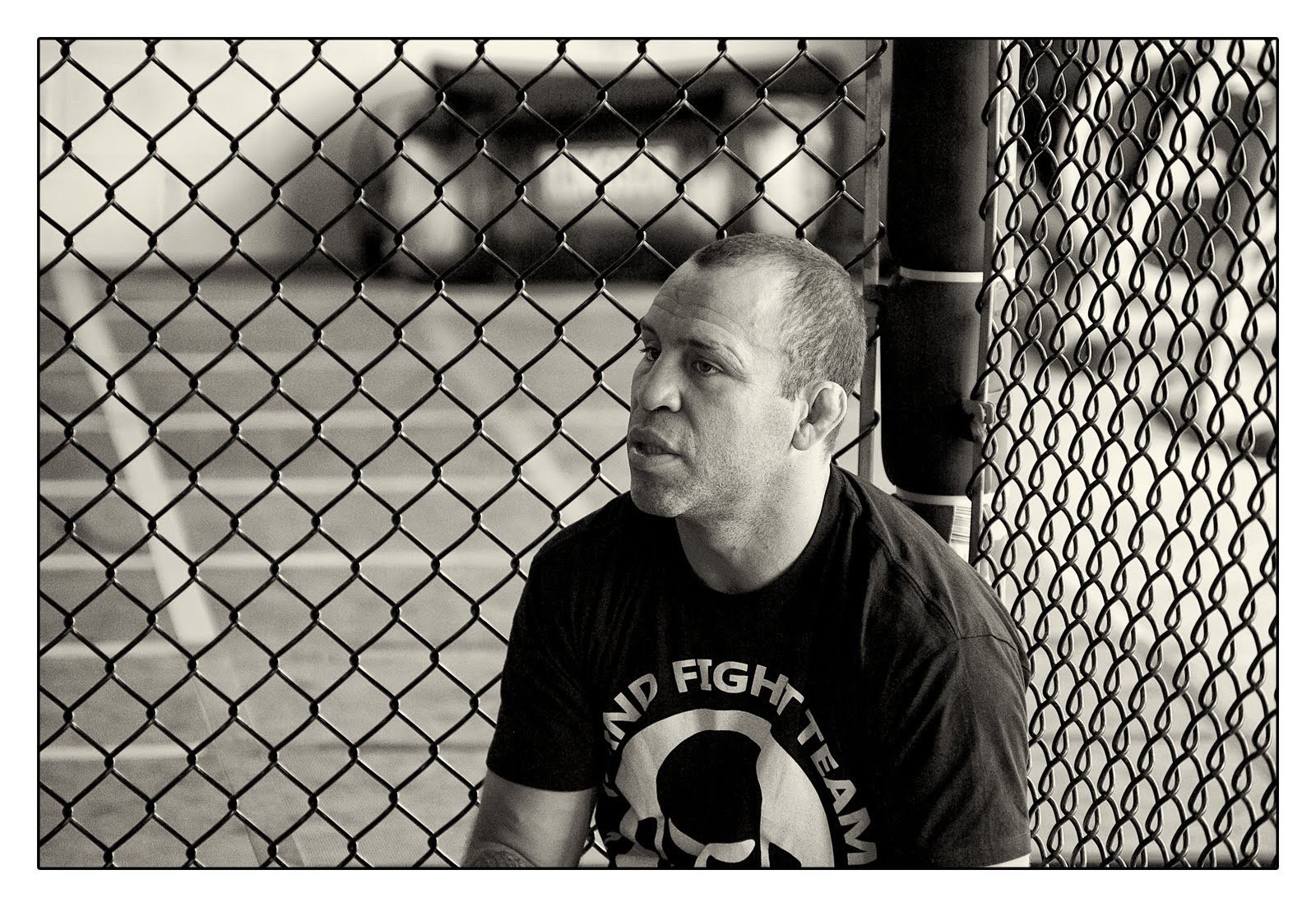 man sitting by fence