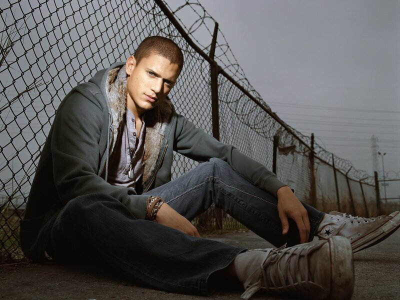 man sitting by fence