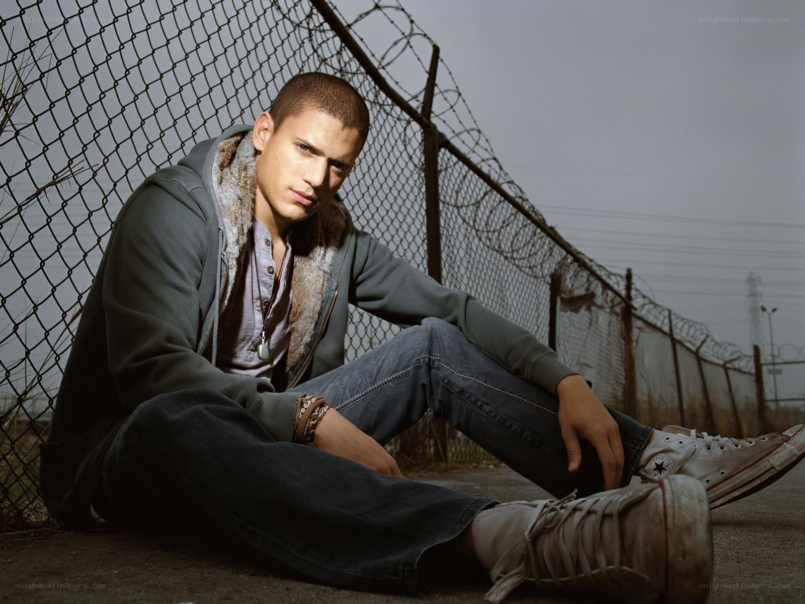 man sitting by fence