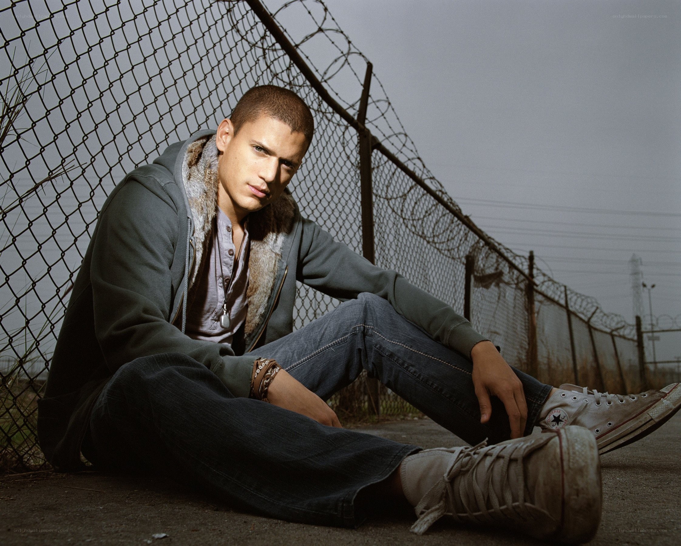 man sitting by fence