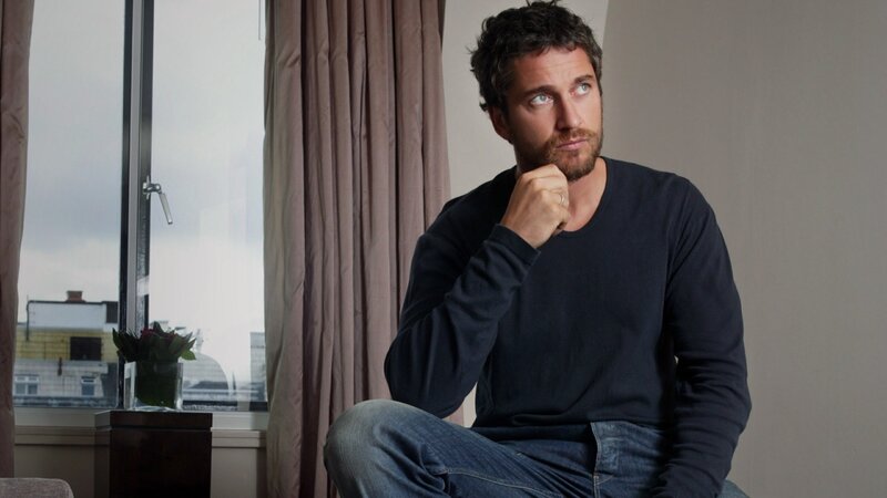 man sitting by window thinking