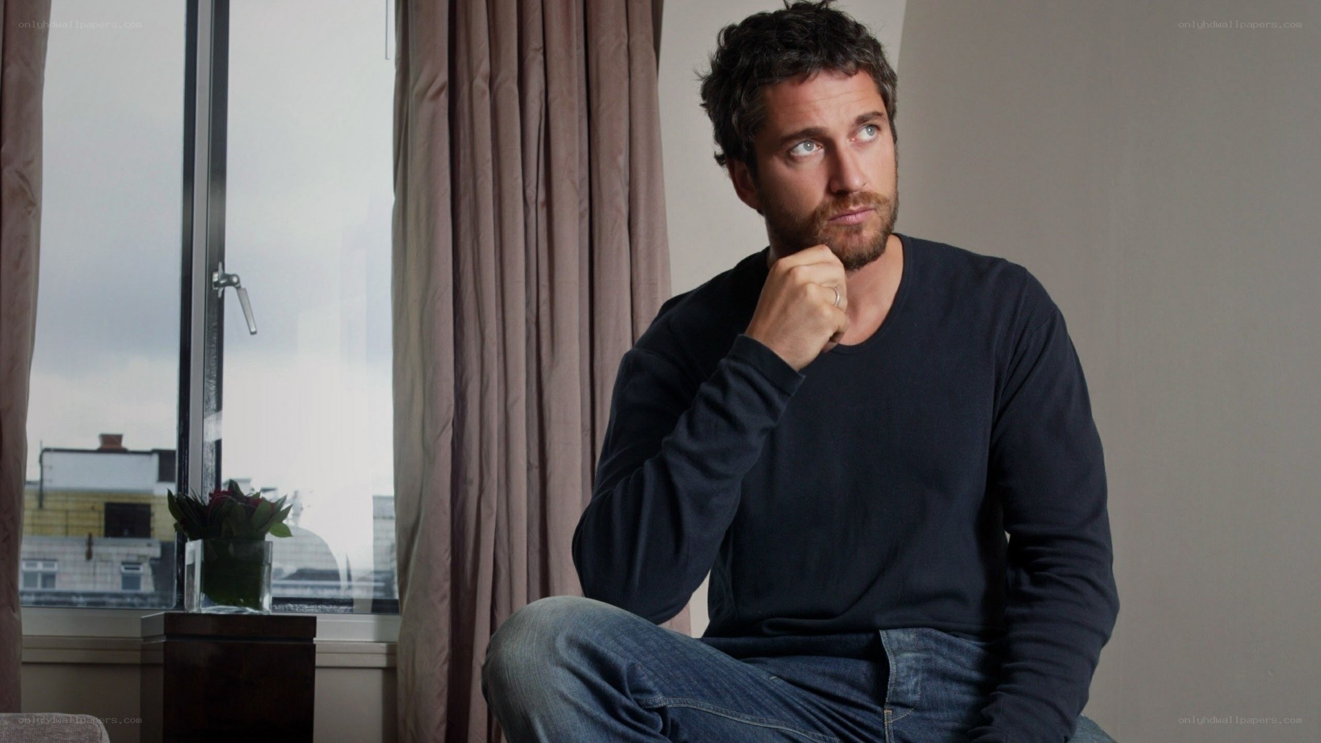 man sitting by window thinking