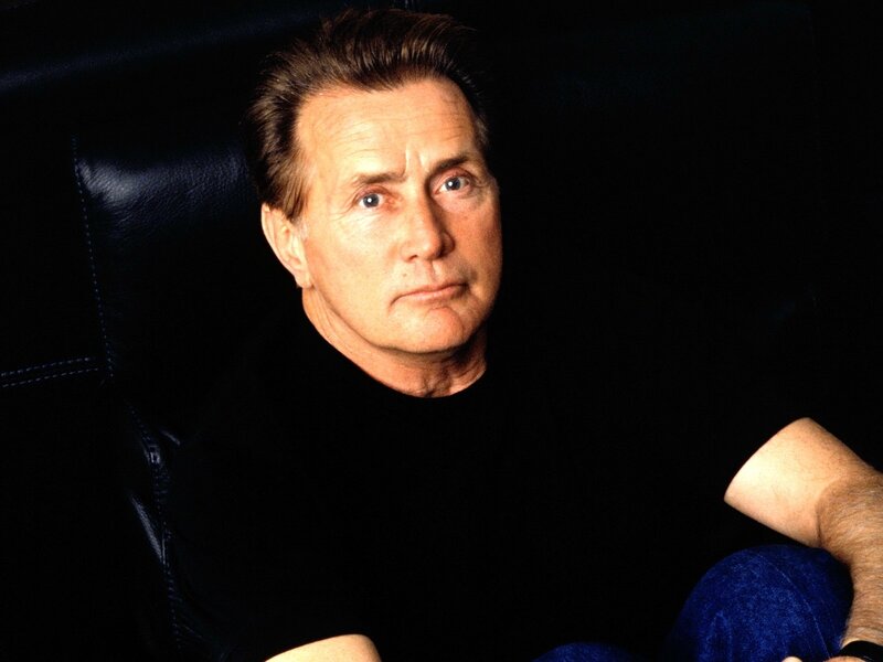Man Sitting in Chair — Black, Serious, Photograph, Jeans